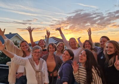 NLP-Premium-Teilnehmerinnen umringen Isabel Ihm und strecken jubelnd die Arme in die Luft