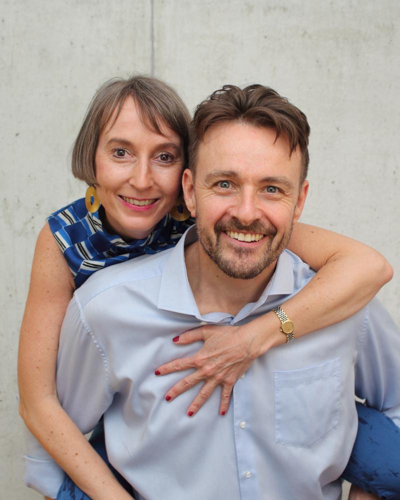 Ein Paar lächelt den Betrachtenden an